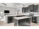 Modern kitchen island with granite countertops, stainless steel appliances, and dark cabinetry at 23233 Banbury Way # 302, Venice, FL 34293