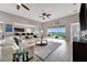 Open-concept living space with kitchen bar, access to the balcony, and a large sectional sofa at 23233 Banbury Way # 302, Venice, FL 34293
