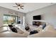 Spacious living area featuring a large sectional sofa, TV, and access to the outdoor balcony at 23233 Banbury Way # 302, Venice, FL 34293