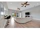 Open-concept living room with a large sectional, wood-look tile floors, and access to a balcony at 23233 Banbury Way # 302, Venice, FL 34293