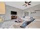 Bright living room features a large sectional, modern ceiling fan and mounted TV at 23233 Banbury Way # 302, Venice, FL 34293