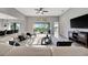 Bright living room with a sectional sofa, outdoor view, kitchen access, and tile flooring at 23233 Banbury Way # 302, Venice, FL 34293