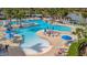 Expansive community pool surrounded by lounge chairs, tables, and palm trees, offering a resort-style experience at 23233 Banbury Way # 302, Venice, FL 34293