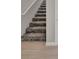 Carpeted staircase with wood-look flooring and white trim at 23233 Banbury Way # 302, Venice, FL 34293