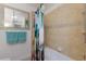 Bathroom featuring tiled shower, patterned curtain, and decorative mirror at 237 85Th St, Holmes Beach, FL 34217