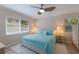 Bright bedroom featuring a ceiling fan, a comfy bed with a blue quilt, and natural light from the windows at 237 85Th St, Holmes Beach, FL 34217