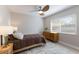 This bedroom features a ceiling fan, a comfy bed with a brown quilt, and natural light from the windows at 237 85Th St, Holmes Beach, FL 34217