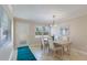 Bright dining area featuring a table with four chairs, a contemporary light fixture, and a large window with blinds at 237 85Th St, Holmes Beach, FL 34217