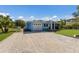 Attractive coastal home with an attached garage, screened porch, nice landscaping, and long gravel driveway at 237 85Th St, Holmes Beach, FL 34217