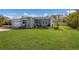 Delightful single-story home showcasing a beautifully maintained lawn, colorful landscaping, and a welcoming screened porch at 237 85Th St, Holmes Beach, FL 34217