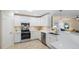 Bright kitchen features white cabinetry, stainless steel appliances, and quartz countertops at 237 85Th St, Holmes Beach, FL 34217