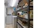 Efficient laundry room featuring a washer, dryer, water heater, and shelving for optimal organization and storage at 237 85Th St, Holmes Beach, FL 34217