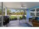 Covered and screened patio with seating area and grill, with a view of the landscaped front lawn at 237 85Th St, Holmes Beach, FL 34217