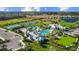 Overhead view showcasing a resort-style pool, clubhouse, tennis courts, playground, and parking at 2578 Wild Cherry Path, Sarasota, FL 34240