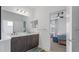 Bright bathroom featuring double vanity, a large mirror, and an open doorway to the bedroom at 2578 Wild Cherry Path, Sarasota, FL 34240
