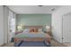 A bedroom features a green accent wall, natural light, and stylish furniture at 2578 Wild Cherry Path, Sarasota, FL 34240