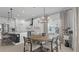 Dining area with a round table, modern light fixture, and large windows, flowing into a modern kitchen at 2578 Wild Cherry Path, Sarasota, FL 34240