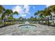 Hot tub near a community pool and clubhouse with palm trees under a bright blue sky at 2578 Wild Cherry Path, Sarasota, FL 34240