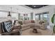 Bright living room features a large sectional sofa, modern lighting, and an open layout to the kitchen at 2578 Wild Cherry Path, Sarasota, FL 34240
