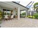 Covered patio offers a relaxing outdoor space with dining and seating areas and brick pavers at 2578 Wild Cherry Path, Sarasota, FL 34240