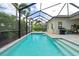 Backyard pool with screen enclosure, grill, and patio area with lush landscaping and sunny skies at 2578 Wild Cherry Path, Sarasota, FL 34240