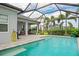 Sparkling pool enclosed by a screen, complemented by a patio and lush tropical landscaping at 2578 Wild Cherry Path, Sarasota, FL 34240