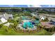 Beautiful aerial view of a large pool area with palm trees, lounge chairs, and clear blue water, surrounded by community amenities at 2578 Wild Cherry Path, Sarasota, FL 34240