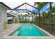 A backyard pool and patio are enclosed by a screen with tropical landscaping at 2578 Wild Cherry Path, Sarasota, FL 34240
