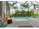 Screened-in pool area surrounded by lush landscaping, providing a private oasis at 2578 Wild Cherry Path, Sarasota, FL 34240
