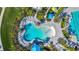 Aerial view of a Gathering-friendly pool featuring a splash zone and lounge areas amidst tropical landscaping at 2578 Wild Cherry Path, Sarasota, FL 34240