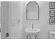 Clean powder room with a pedestal sink, mirror, and classic design elements at 2578 Wild Cherry Path, Sarasota, FL 34240