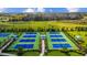 View of tennis courts in the community, surrounded by palm trees and offering recreational opportunities at 2578 Wild Cherry Path, Sarasota, FL 34240