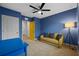 Charming bedroom with blue walls, yellow sofa, desk, and ceiling fan at 2721 Greenleaf Ter, Parrish, FL 34219