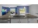 Kitchen island sink with granite countertop overlooks the breakfast nook and blue living room at 2721 Greenleaf Ter, Parrish, FL 34219
