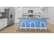 Bright kitchen features white cabinets, granite countertops, stainless steel appliances and a blue breakfast bar at 2721 Greenleaf Ter, Parrish, FL 34219