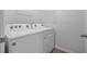 Laundry room featuring a white washer and dryer set with overhead storage racks at 2721 Greenleaf Ter, Parrish, FL 34219