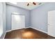 This bedroom has hardwood floors, a ceiling fan, a window, and a closet at 296 Pine Ranch Trl, Osprey, FL 34229