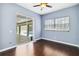This bedroom has hardwood floors, a ceiling fan, a window, and a sliding glass door to the pool at 296 Pine Ranch Trl, Osprey, FL 34229