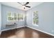 This bedroom has hardwood floors, two windows, a ceiling fan, and neutral colored walls at 296 Pine Ranch Trl, Osprey, FL 34229
