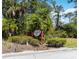 Pine Ranch East sign with palm trees and landscaping at 296 Pine Ranch Trl, Osprey, FL 34229