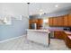 Kitchen with wood cabinets, stainless steel appliances, and a tiled breakfast bar at 296 Pine Ranch Trl, Osprey, FL 34229