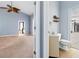 Angled view into main bedroom and bathroom with tile floors and ceiling fan at 296 Pine Ranch Trl, Osprey, FL 34229