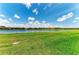 Expansive grassy lawn extends to a tranquil lake under a beautiful sky at 3027 Formia Ct, Lakewood Ranch, FL 34211