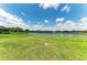 Lush green backyard that overlooks a serene lake with clear blue skies above at 3027 Formia Ct, Lakewood Ranch, FL 34211