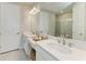 Bathroom with double vanity sinks, white cabinets, and a glass-enclosed shower at 3027 Formia Ct, Lakewood Ranch, FL 34211