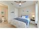 Bright bedroom features a ceiling fan, patterned bedding, accent pillows, and ensuite bathroom at 3027 Formia Ct, Lakewood Ranch, FL 34211