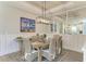 Elegant dining room with wainscoting, stylish chandelier, and large art piece, designed for entertaining at 3027 Formia Ct, Lakewood Ranch, FL 34211