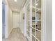 Bright hallway featuring French doors opening to an office space with wood-look tile flooring and neutral paint at 3027 Formia Ct, Lakewood Ranch, FL 34211