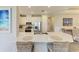 Modern kitchen with white cabinetry, stainless steel appliances, large island with seating, and natural lighting at 3027 Formia Ct, Lakewood Ranch, FL 34211