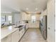 Bright kitchen features stainless steel appliances, white cabinets, and a large sink with an island at 3027 Formia Ct, Lakewood Ranch, FL 34211
